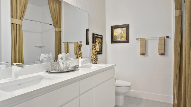 EVOLVE Apartments - Apartment Bathroom with White & Gold Furnishing, Toilet, and Sink.
