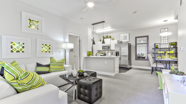 Evolve Apartments - Apartment Interior with Green & White Furniture and Kitchen in View